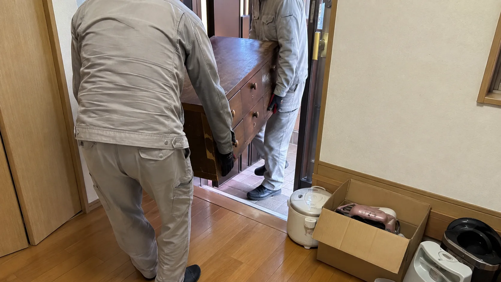 和箪笥と家電を室内から搬出する作業員2名