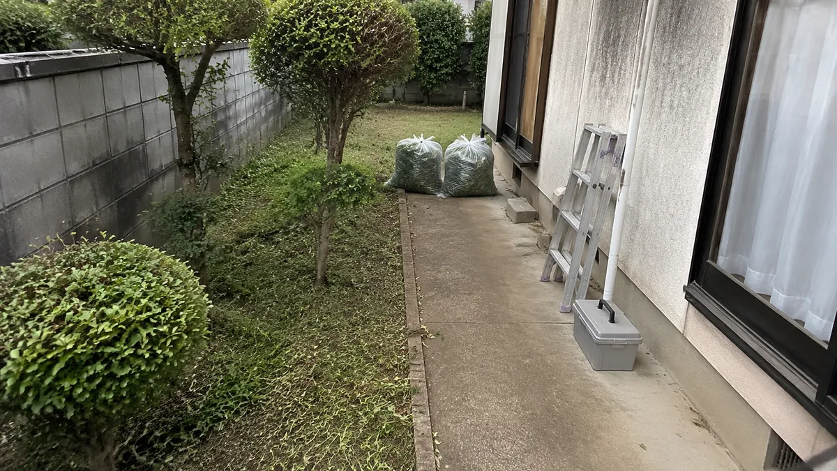 草刈りと庭木の手入れを終えたお庭。刈った草は袋にまとめてある